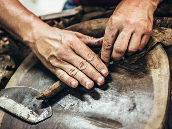 Close-up of manual worker making cigar in factory