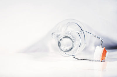 Close-up of glass bottle on table against white background