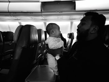Father playing with daughter while traveling in airplane