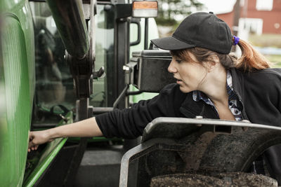 Female farmer repairing tractor