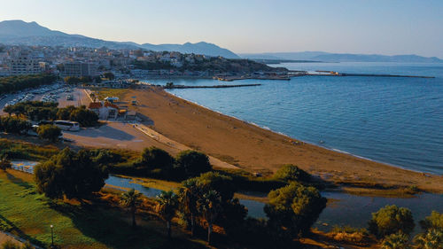 High angle view of townscape by sea against sky