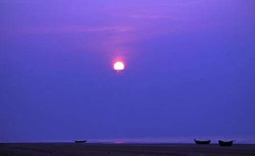 Scenic view of beach against blue sky at night