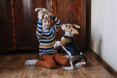 Boy playing with dog on floor at home