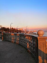 Bridge over street against clear sky during sunset