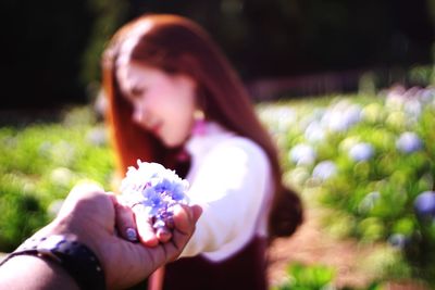 Midsection of woman holding flowering plant