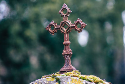 Close-up of metal cross against blurred background