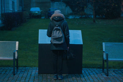 Rear view of woman standing at park in city