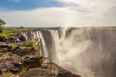 Scenic view of waterfall against sky