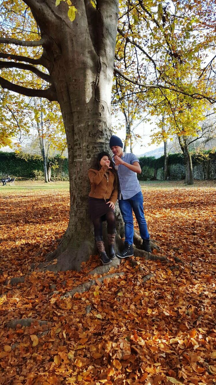 tree, lifestyles, leisure activity, full length, autumn, tree trunk, casual clothing, leaf, change, nature, childhood, forest, park - man made space, person, day, rear view, men, season