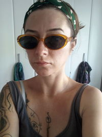 Portrait of young woman wearing sunglasses at home