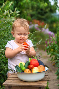 Portrait of cute baby boy holding fruit
