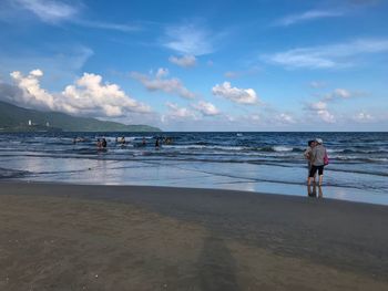 People on beach against sky