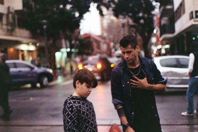 Father and son on street in city at sunset