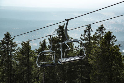 Low angle view of overhead cable car against sky