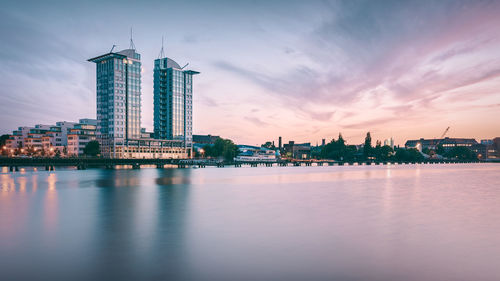 Twintowers berlin by spree river against sky during sunset