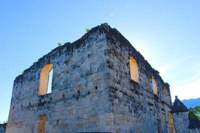 Low angle view of old building against blue sky