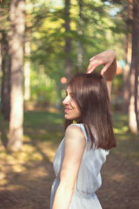 Side view of woman standing in forest