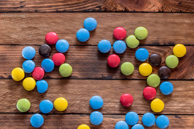 High angle view of multi colored candies on wooden table