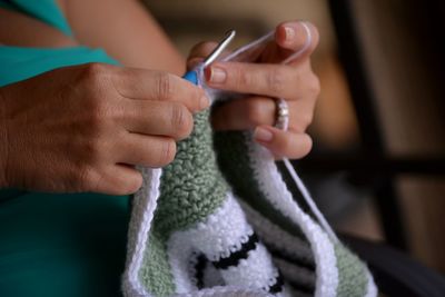 Midsection of woman making crochet