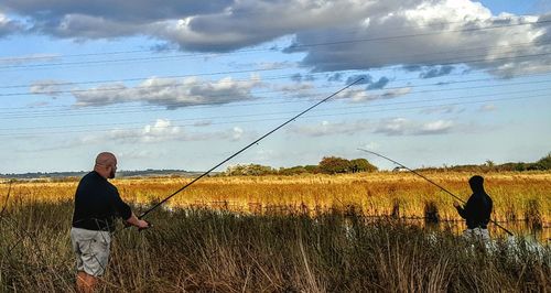 Rear view of man standing on grassy field