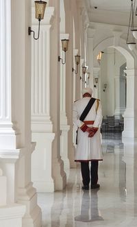 Rear view of woman standing in corridor of building