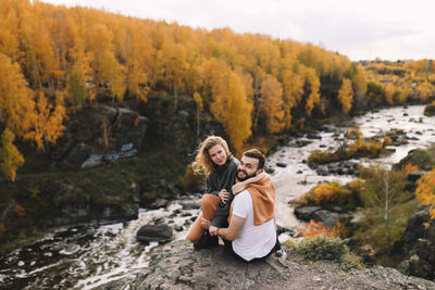 Happy people in love are travel hike in nature in the autumn forest. romantic trip to countryside