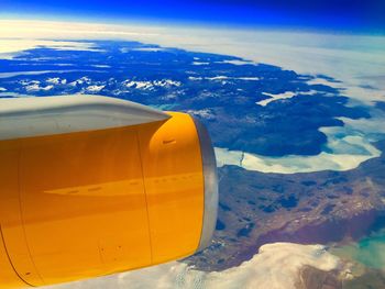 Aerial view of airplane wing over landscape