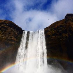 Low angle view of waterfall against sky