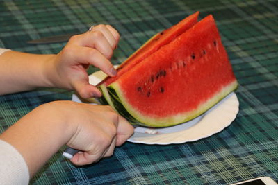 Cropped image of woman cutting watermelon