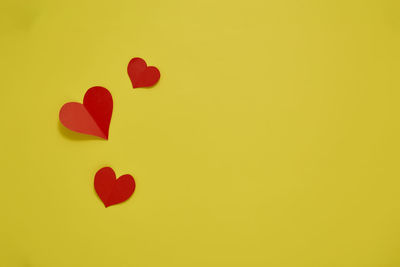 Close-up of red heart shape against yellow background