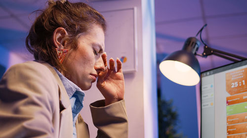 Side view of young woman using mobile phone