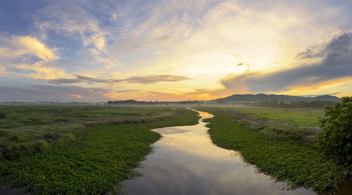 Scenic view of field against sky during sunset