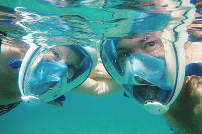 Senior couple swimming underwater 