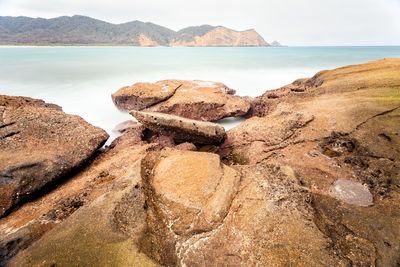 Panoramic view of rocks on beach against sky