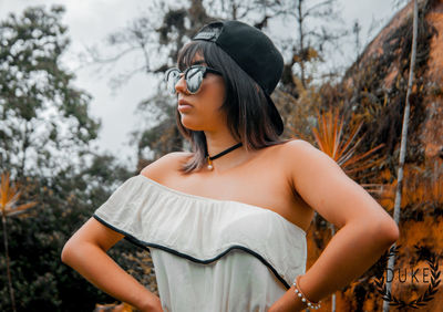 Young woman looking away while standing on land