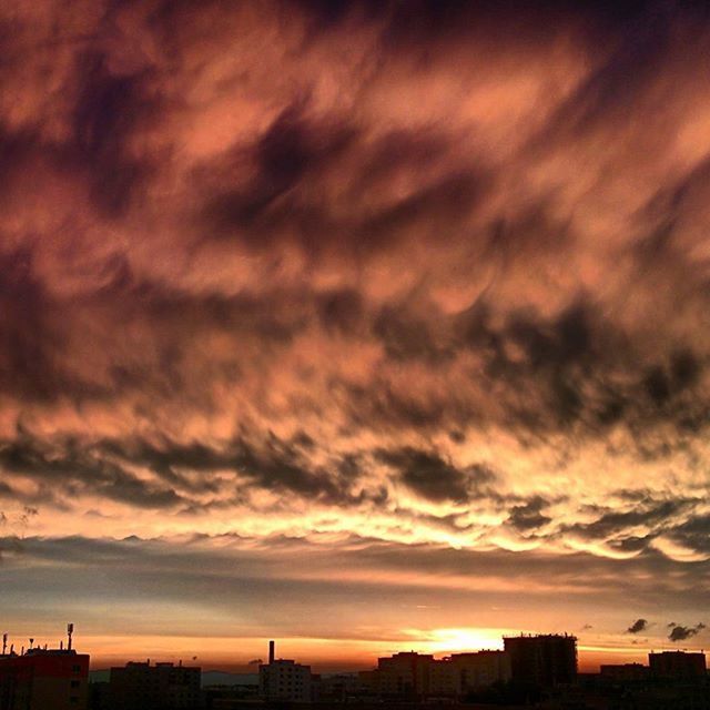 sunset, sky, building exterior, cloud - sky, architecture, built structure, silhouette, cloudy, city, dramatic sky, orange color, weather, cloud, beauty in nature, scenics, overcast, cityscape, moody sky, atmospheric mood, nature