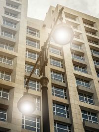 Low angle view of illuminated street light against building