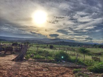 Scenic view of field against cloudy sky