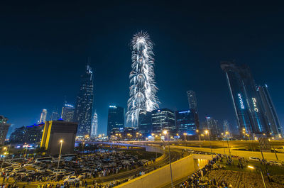 Illuminated modern buildings against sky at night