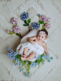 High angle view of cute girl with flowers on table