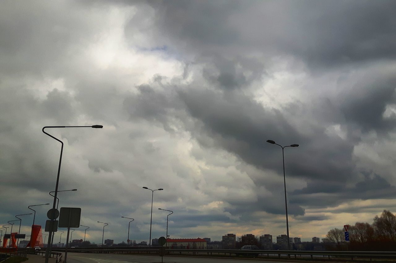 LOW ANGLE VIEW OF BIRDS FLYING OVER CITY AGAINST SKY