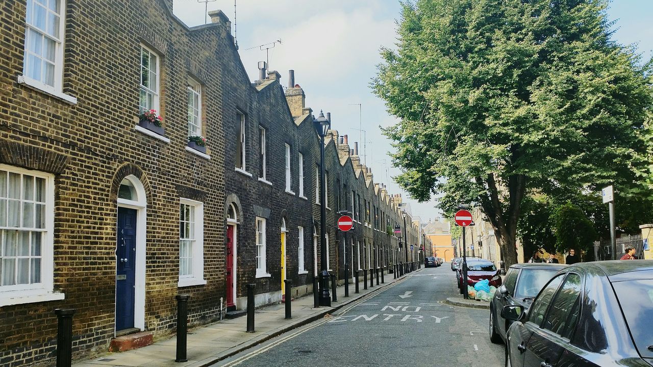 building exterior, architecture, built structure, street, city, the way forward, residential building, transportation, tree, road, car, residential structure, building, sky, incidental people, day, in a row, house, outdoors, land vehicle