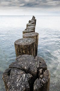 Close-up of pier on sea against sky