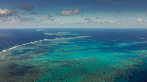 Aerial view of great barrier reef against blue sky