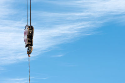 A hook of a crane with blue sky as a background