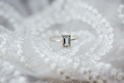 Close-up of wedding ring on white textile