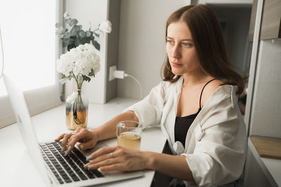 Young woman using laptop at home