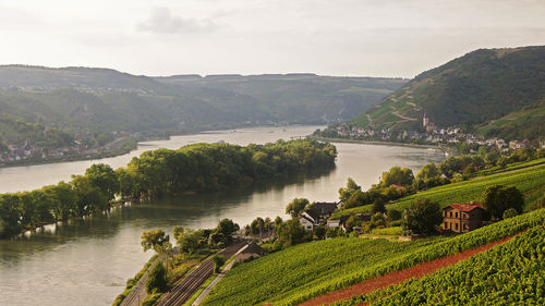 Scenic view of river by mountains against sky