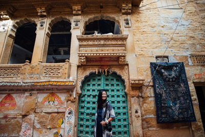 Reflection of woman standing on wall of historic building