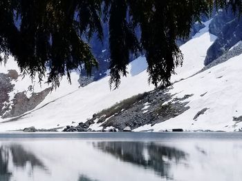 Scenic view of lake by snowcapped mountain against sky